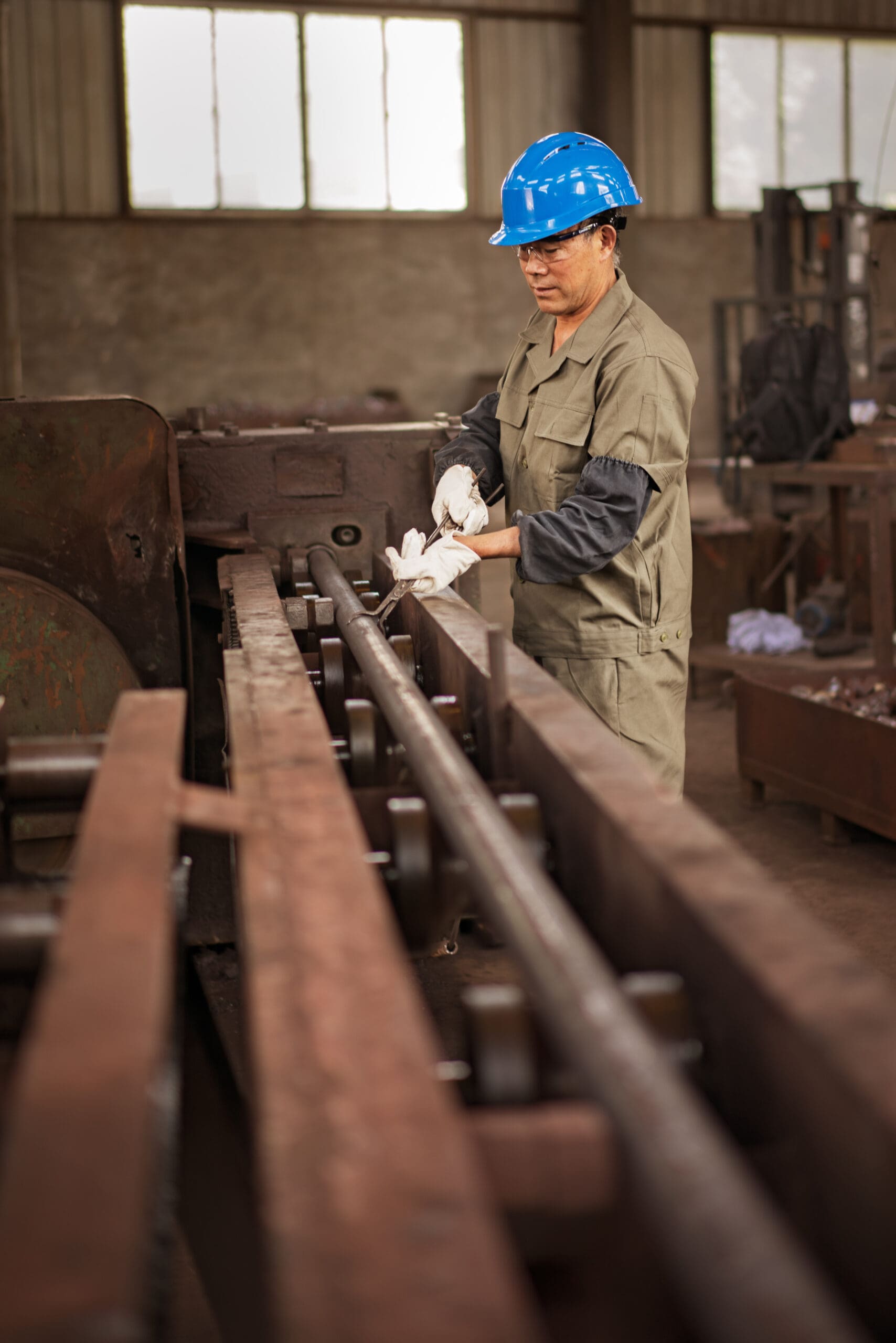 Worker preparing large diameter bar stock for near net shape forgings.