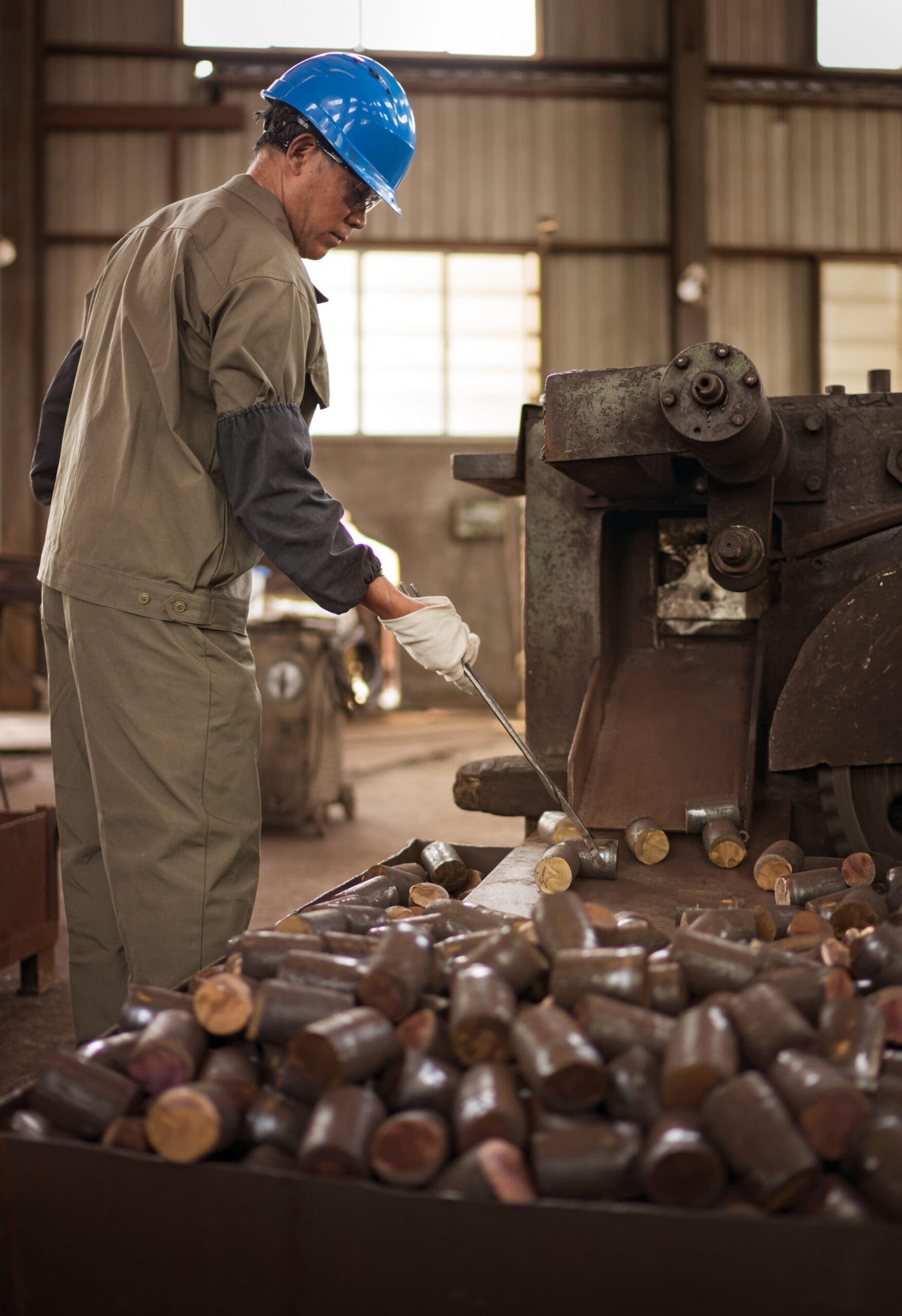 Worker preparing large diameter bar stock for near net shape ring forging.