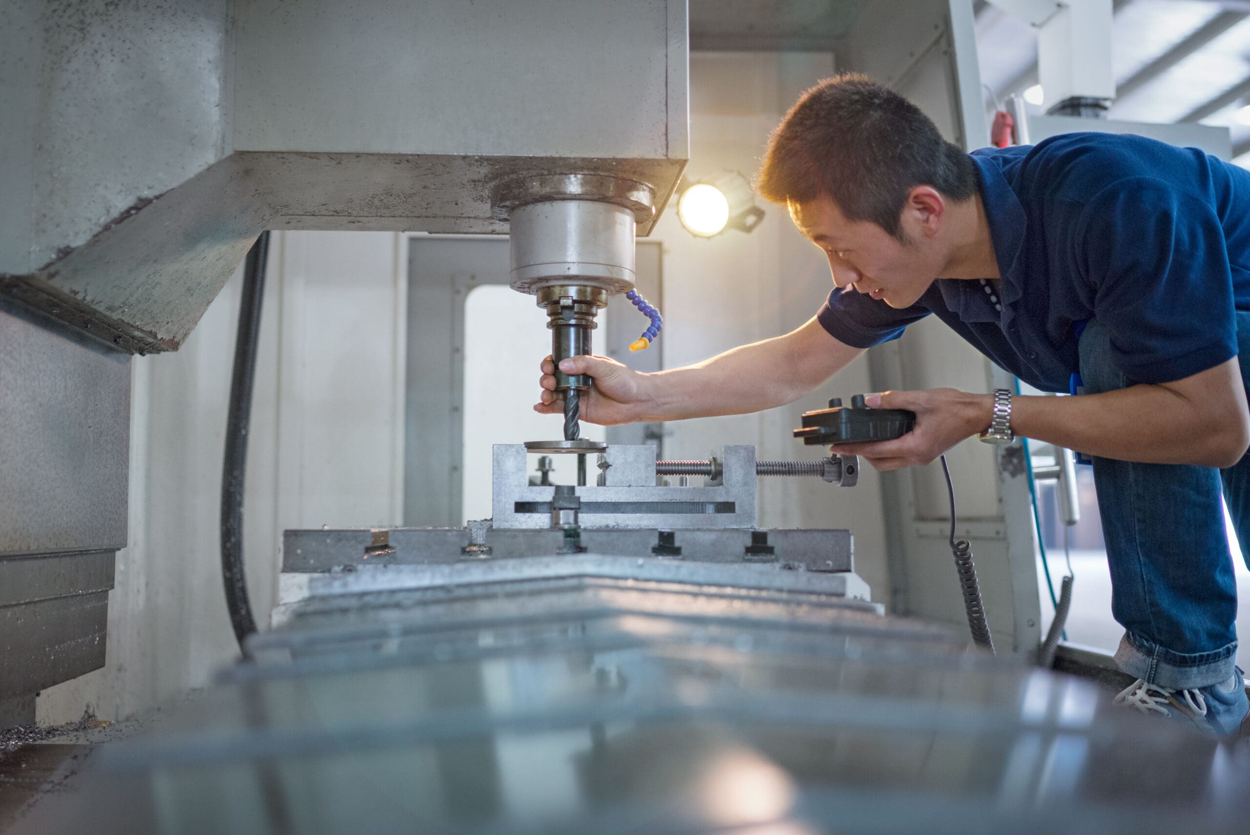 Machine operator preparing an advanced CNC machine for complex industrial parts production.