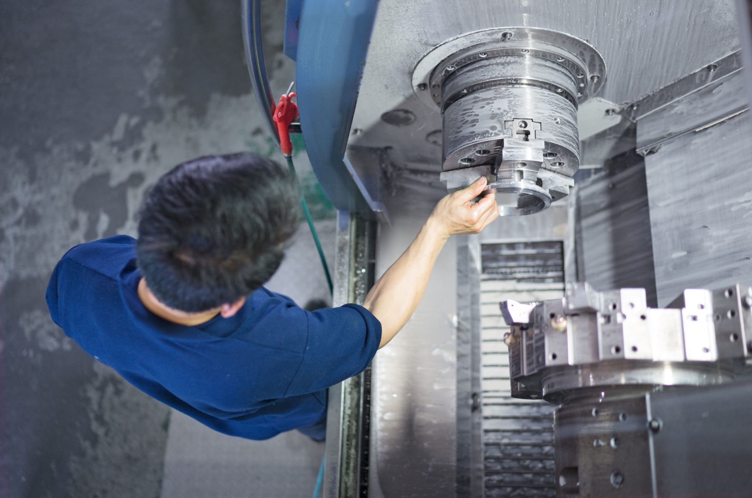 Machine operator adjusting the chuck on an HMC machine to finish complex ring rolled forgings.